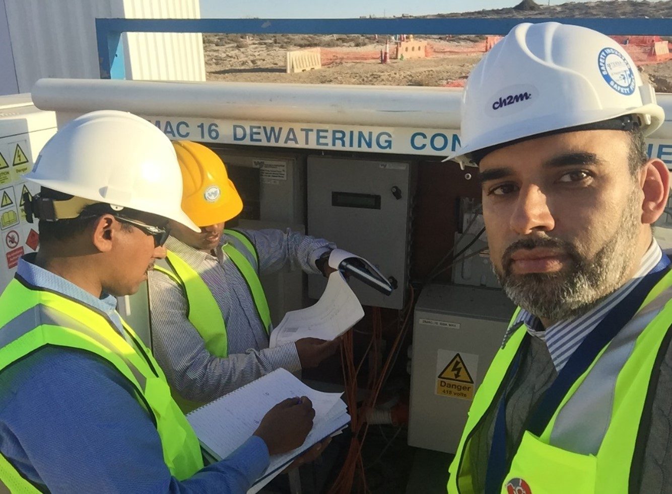 Engineers inspecting a dewatering control panel