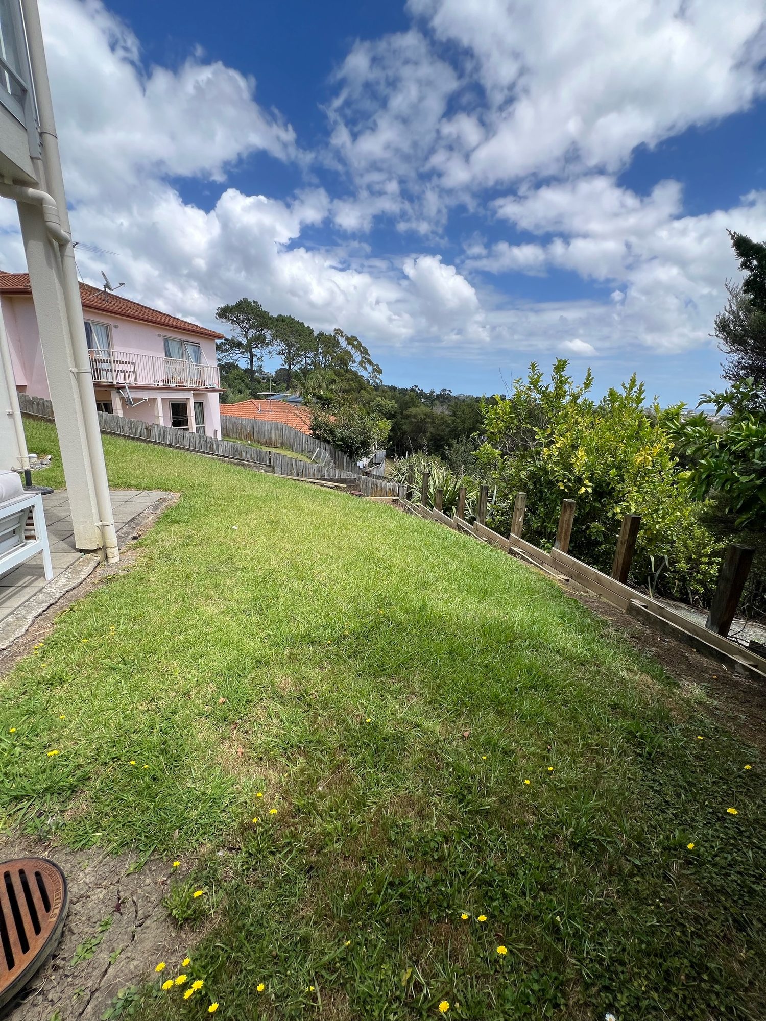 Residential backyard on sloping ground with a timber retaining wall