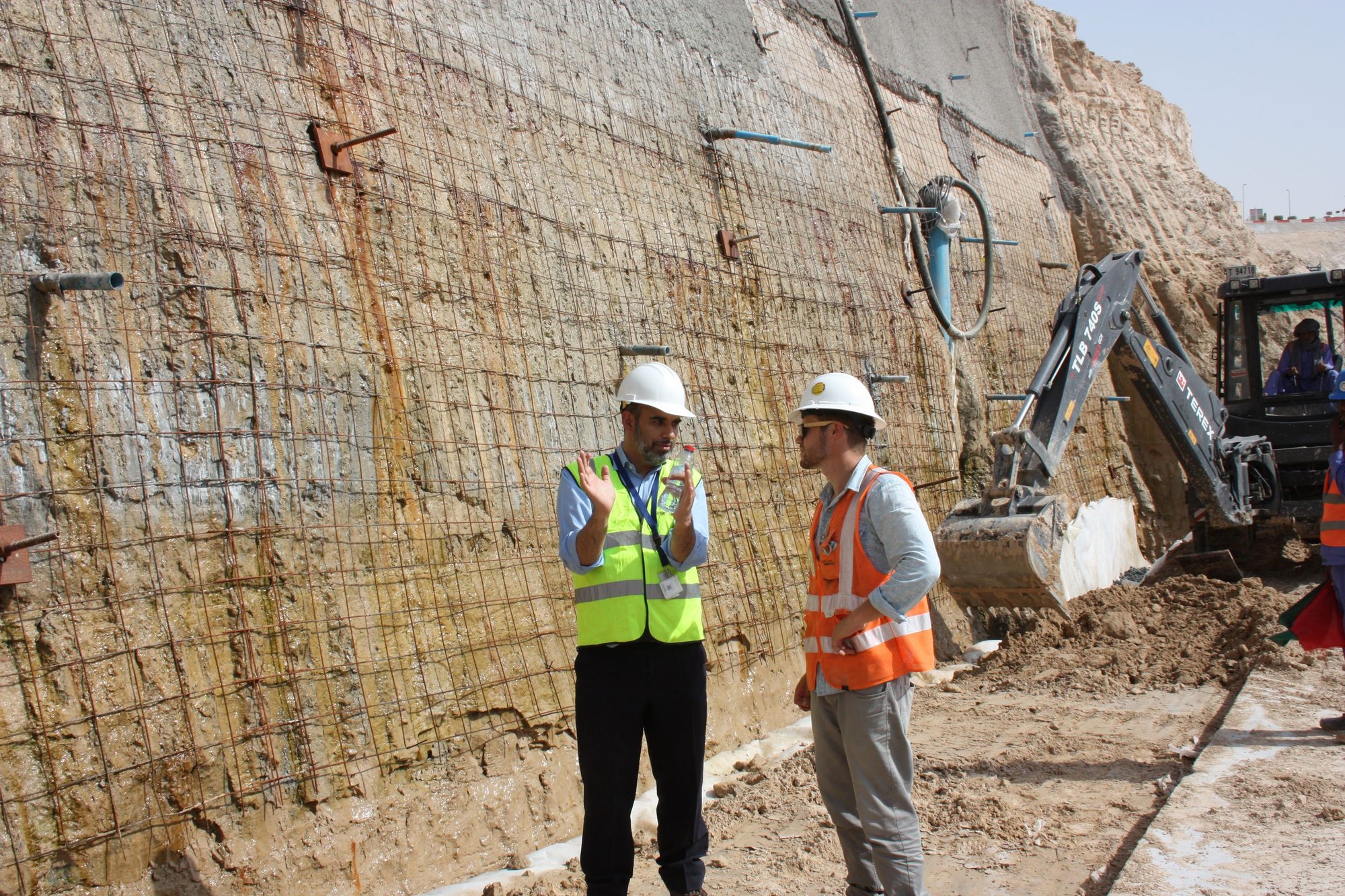 Engineers discussing a soil-nailed wall on site